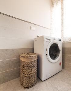 una lavatrice in una lavanderia con cesto di Casa di Marita a Finale Ligure