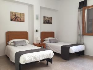 2 łóżka w pokoju z białymi ścianami w obiekcie Sol y Luna Cala Millor w Cala Millor