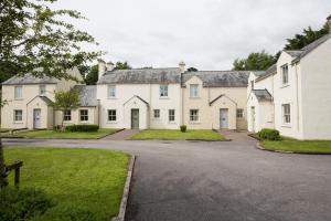 a row of white houses with a driveway at Bunratty Castle Gardens Home in Bunratty