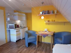 a small kitchen with a table and two chairs at Dat Inselhuus in Norden