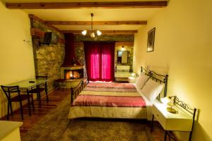 a bedroom with a bed and a table and a fireplace at Village Inn in Ano Chora