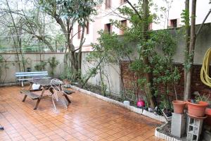 a patio with a table and a bench and trees at La Petite Auberge de Saint-Sernin in Toulouse