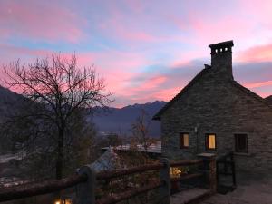 an old stone building with a sunset in the background at Agriturismo La Tensa in Domodossola