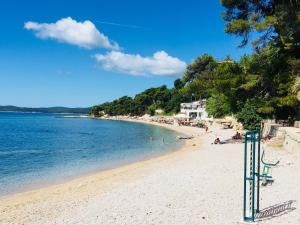 ein Strand mit Menschen, die im Wasser schwimmen in der Unterkunft Apartmani Slavonija in Orebić