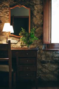 a dresser with a mirror and a lamp on it at Hotel Caldas in Caldes de Boi