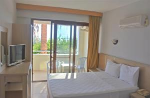 a bedroom with a bed and a desk and a television at Dikelya Hotel in Dikili