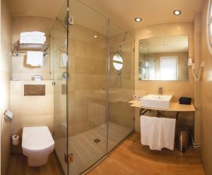 a bathroom with a shower and a toilet and a sink at Hotel J. Balmes Vic in Vic