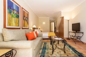 uma sala de estar com um sofá e uma cama em Pestana Palm Gardens em Carvoeiro