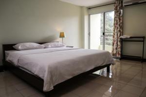 een slaapkamer met een groot bed en een raam bij Udoncabana in Udon Thani