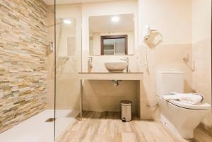 un baño con inodoro y lavabo en Hotel Atiana, en Albarracín
