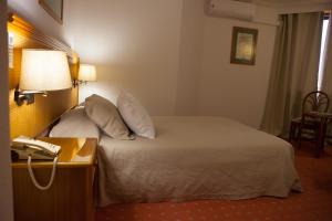 Uma cama ou camas num quarto em Hotel Lusitano