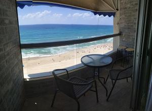 a room with a view of the beach from a window at Apart Hotel TLV/Bat Yam Beach Front 1207 in Bat Yam