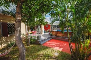 une maison dotée d'un tapis rouge en face d'une piscine dans l'établissement Villa Yapaplupres, à Saint-Leu