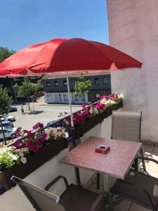 a table with a red umbrella on a balcony with flowers at Wondervolles zuhause auf Zeit in Moers