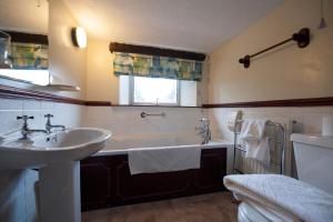 y baño con lavabo y bañera. en Cwmwennol Country House, en Saundersfoot