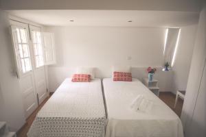 two beds in a small room with white walls at Bela Vista Silo Housing in Alfândega da Fé