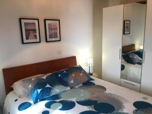 a bedroom with a bed with blue pillows and a mirror at BHF Residences Bordadeira in Arco da Calheta