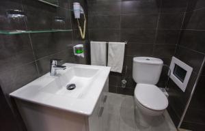 
a white toilet sitting next to a sink in a bathroom at Atlantic Hotel Agadir in Agadir
