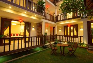 a courtyard of a house with a table and chairs at Village Moon Villa in Hoi An
