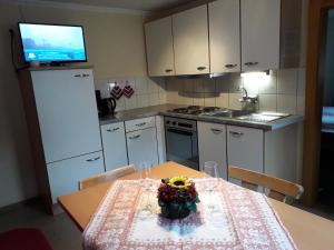 a kitchen with a table with a vase of flowers on it at Nieslerhof in Mayrhofen