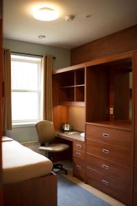 um quarto com uma secretária, uma cama e uma janela em Grenfell Campus Summer Accommodations em Corner Brook