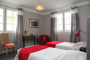 a bedroom with two beds and a table and a chair at Gure Lana in Saint-Jean-Pied-de-Port