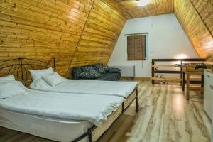 um quarto com uma cama num quarto com tecto em madeira em Jázmin Weekend House em Makó