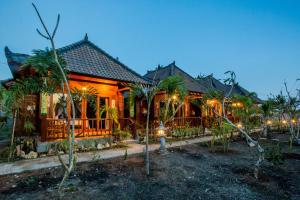 a house with lights on the front of it at Mimpi Cottages in Nusa Lembongan