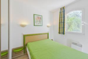 a bedroom with a green bed and a window at Residence Saint-Raphael Valescure - maeva Home in Saint-Raphaël +48 photos