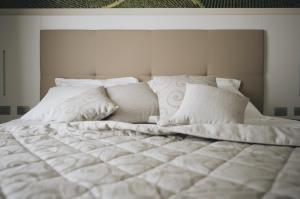 a large bed with white sheets and pillows at Cascina Speranza Hotel in Riva presso Chieri
