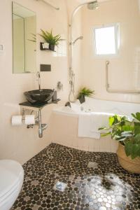 ein Badezimmer mit Badewanne, Toilette und Waschbecken in der Unterkunft Nuriel Fruit & Guest House in Sheʼar Yashuv + 47 Fotos