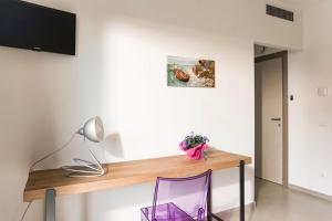 ザッフェラーナ・エトネーアにあるB&B Etna Dreamのランプと紫色の椅子が置かれた机のある部屋