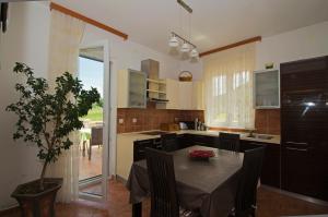 a kitchen with a table with chairs and a dining room at Rooms Leda in Vrlika