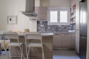 una cocina con encimera y taburetes. en city apartment, en Ermoupoli