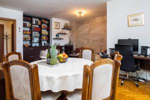 una sala da pranzo con tavolo, sedie e ghiacciaio di Apartment Bucka a Spalato (Split)