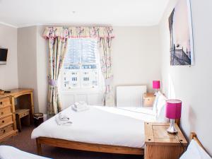 a bedroom with a bed and a window at The Queensbury Hotel in Brighton & Hove