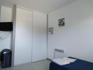 a room with a bed and a large white closet at Pescalis Résidence Les Maisons du Lac in Moncoutant +53 photos