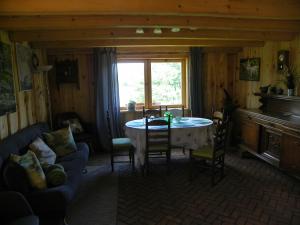 a living room with a table and chairs and a window at Dom Letniskowy Ostaszewo in Hartowiec