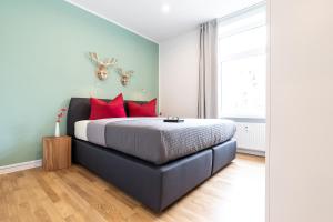 een slaapkamer met een groot bed met rode kussens bij Freiburg Apartments Friedrichring in Freiburg im Breisgau