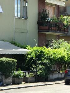 un edificio con un montón de arbustos al lado de una calle en Olimpia House room, en Verona