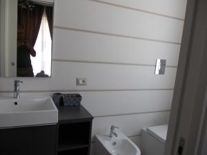 um homem tirando uma foto de uma casa de banho com um lavatório em VILLA LAURO LUXURY B&B em Castellabate