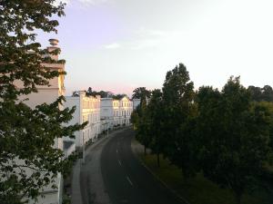 Blick auf eine Straße mit Bäumen und Gebäuden in der Unterkunft Fürstlich Wohnen am Circus über den Dächern von Putbus in Putbus