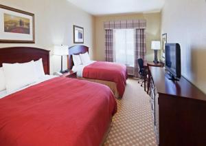 Un pat sau paturi într-o cameră la Country Inn & Suites by Radisson, Tulsa, OK