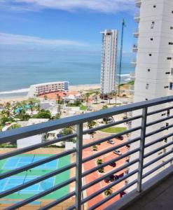 einen Balkon mit Blick auf den Strand und die Gebäude in der Unterkunft Ocean Club Playas in Playas