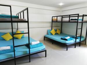 two bunk beds in a room with blue pillows at Wanlapa Farmstay in Ban Khok Krathiam +41 photos