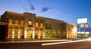 a building on the side of a street at night at Hotel Plaza las Quintas in Hermosillo +11 photos