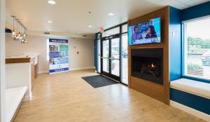 Habitación con chimenea y TV en la pared. en Uptown Suites Extended Stay Miami FL – Homestead en Homestead