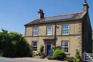 una vieja casa de ladrillo con una puerta azul en Ashtree House Bed and Breakfast, en Thornton