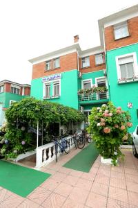 un edificio verde con bicicletas estacionadas frente a él en Hotel Kaduku en Shkodër