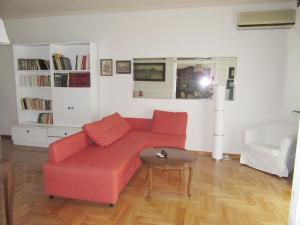 un soggiorno con divano rosso e tavolo di Luxury in the city heart a Salonicco